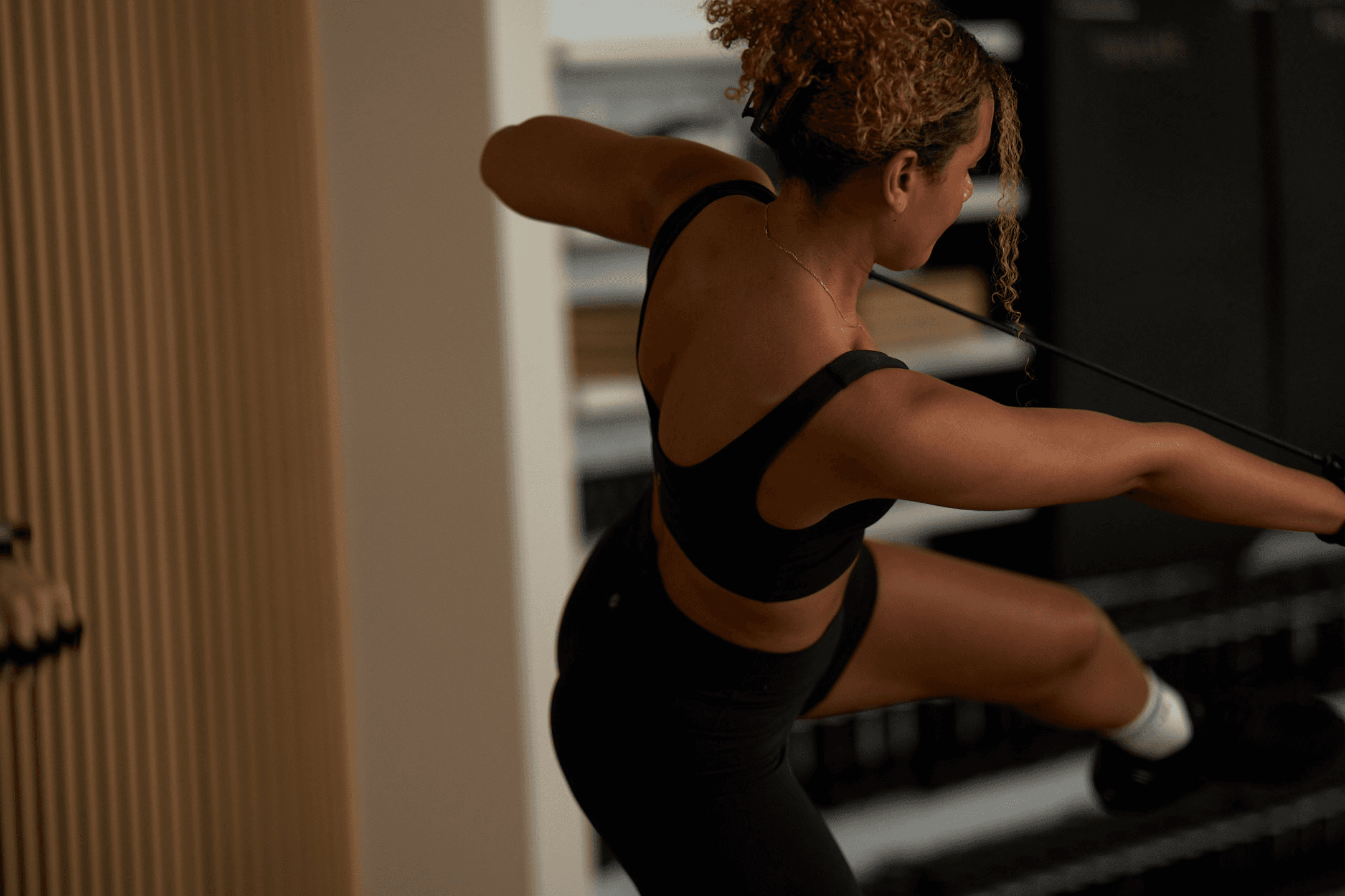 Back of woman exercising in PVOLVE studio